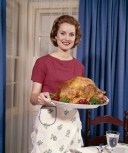 1960s Woman Serving Thanksgiving Turkey Dinner